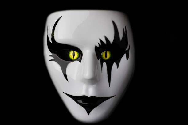 istock Masquerade face mask scary mask for Halloween with hand made monster eyes hand sprayed by photographer with dramatic lighting black and autumn leaf background 1362006456