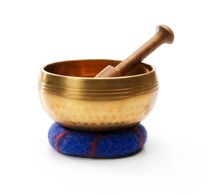 This is a photograph taken in the studio of a Buddhist singing golden bowl isolated on a white background