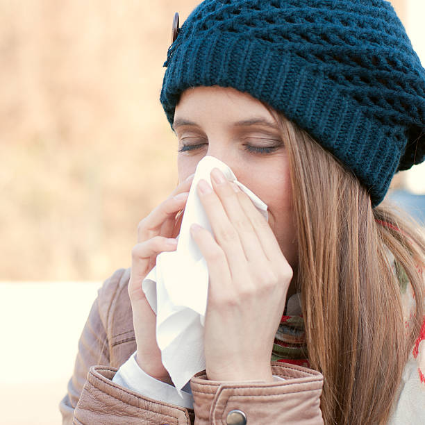 istock A woman with the flu blowing her nose 136201174