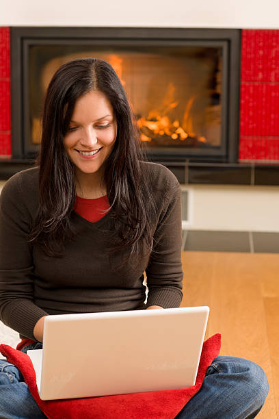 istock Home living happy woman work computer fireplace 136201435