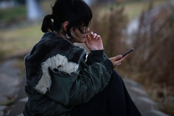 A woman who is depressed looking at a smartphone