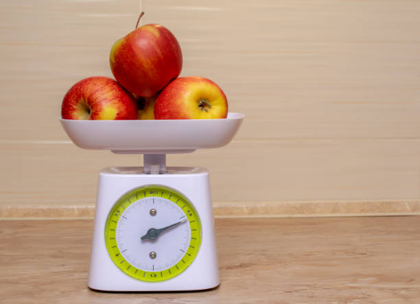 jabłka na wskaźniku skali - weight scale apple comparison balance zdjęcia i obrazy z banku zdjęć