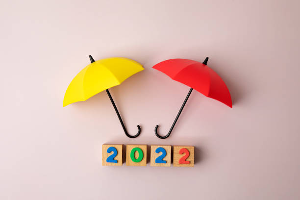 istock New Year 2022 with two umbrellas on pink background 1362038239
