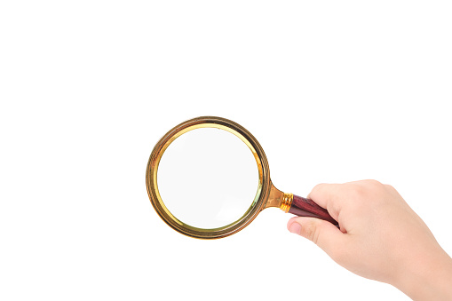 Magnifying glass in child hand on white background, isolate