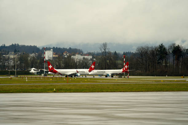 aéroport suisse zürich kloten avec fond de ciel nuageux. - runway airport sky wet photos et images de collection