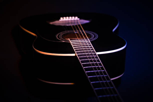 istock black guitar against split colored background. guitar music low-key concept 1362054825