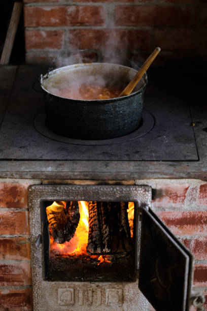 istock Cast iron cauldron boiling a goulash stew over a wood burning stove made from red bricks in the backyard of a rural house in Romania. 1362060613