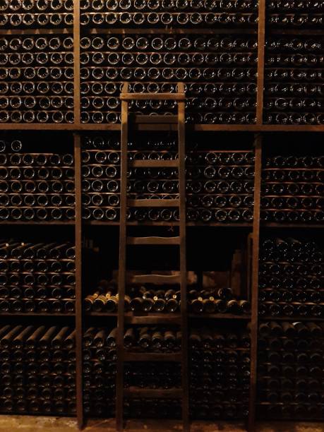 The wine cellar A full storge of neatly stacked wine bottles in dim lighting stackable stock pictures, royalty-free photos & images