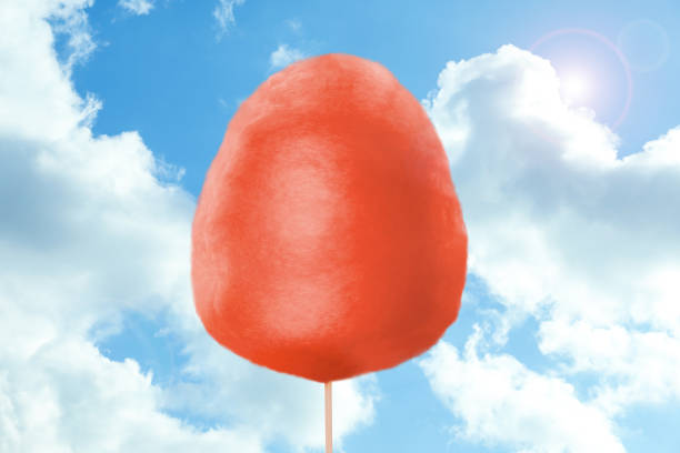 istock Red cotton candy against blue sky with clouds 1362066614
