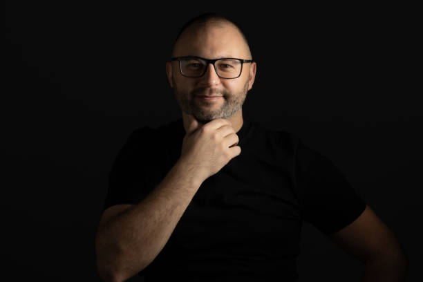 istock A man with glasses poses with his hand under his chin looking at the camera 1362067016