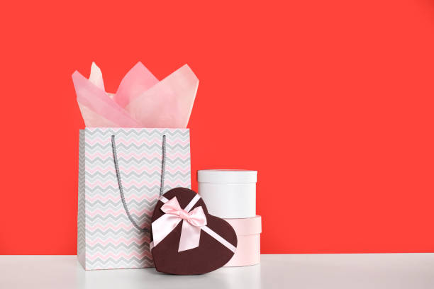 istock Shopping paper bag and gift boxes on red background. Space for text 1362069428