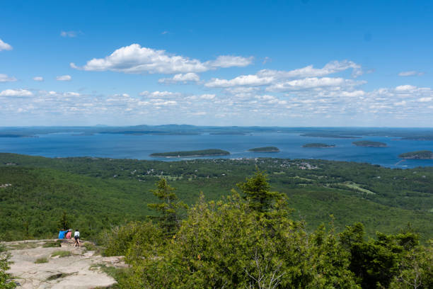 escursionisti in lontananza che si affacciano su frenchman's bay sulla strada per cadillac mountain nel parco nazionale di acadia, maine, usa - cadillac mountain maine new england usa foto e immagini stock