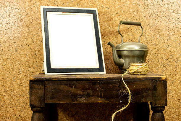 still life: empty picture frame mockup on wooden old desk table. old silver teapot and rope. Elegant working space, home office concept