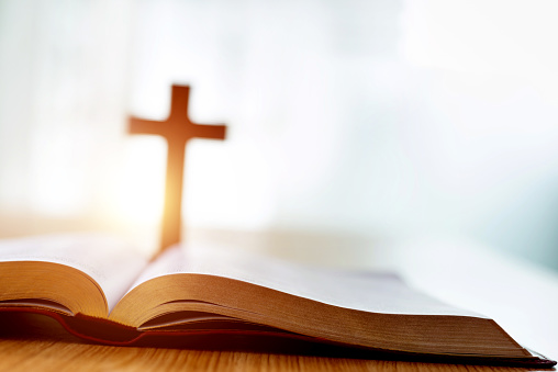 Biblia y cruz religiosa sobre escritorio de madera photo