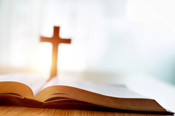bíblia e cruz religiosa sobre mesa de madeira - religious text cross protestantism reading - fotografias e filmes do acervo