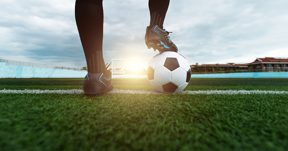 Soccer player playing soccer ball on sports field.