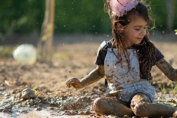 istock Little girl playing with dirt mud 1362078701