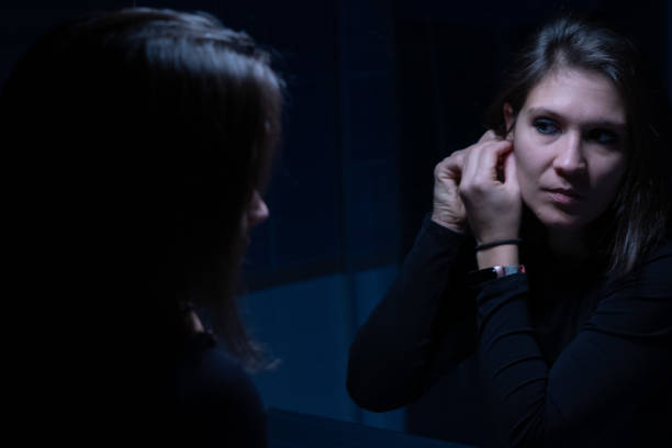 uma jovem adulta olhando para o rosto através do espelho antes da maquiagem - mirror women kissing human face - fotografias e filmes do acervo