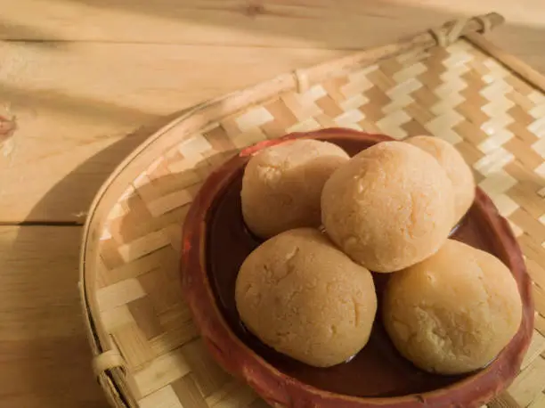 Photo of nolen gur rosogolla or rasgulla served on plate. brown spongy bengali indian traditional sweet made from cottage cheese and jaggery. winter special delicacy.