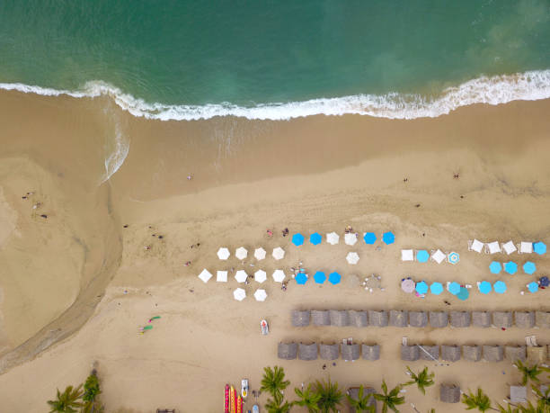 vista aerea della spiaggia con ombrelloni e dolci onde ad acapulco - acapulco mexico sunset day foto e immagini stock