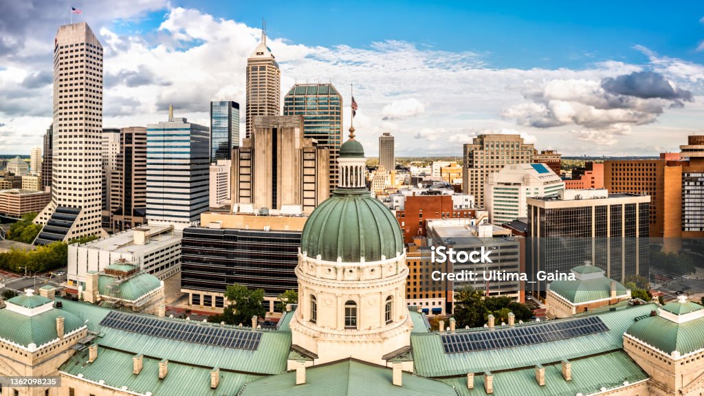 Indiana Statehouse and Indianapolis skyline on a sunny afternoon. Drone view of the Indiana Statehouse, in Indianapolis. Indiana Statehouse houses the General Assembly, the office of the Governor, the Supreme Court, and other state officials. Indiana Stock Photo