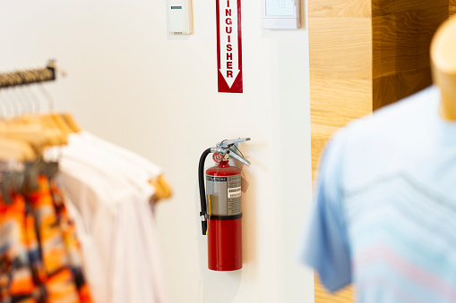 A fire extinguisher properly installed on a wall in a retail store