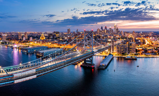 Aerial panorama with Ben Franklin Bridge and Philadelphia skyline Aerial panorama with Ben Franklin Bridge and Philadelphia skyline in transition from sunset to dusk. Ben Franklin Bridge is a suspension bridge connecting Philadelphia and Camden, NJ. philadelphia stock pictures, royalty-free photos & images