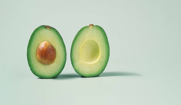 istock Avocado halves close up on a light green background. 1362101534