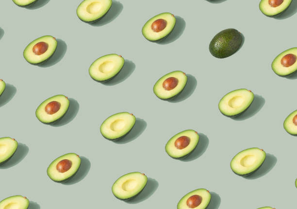 istock Avocado halves arranged on a pastel green background. 1362102666