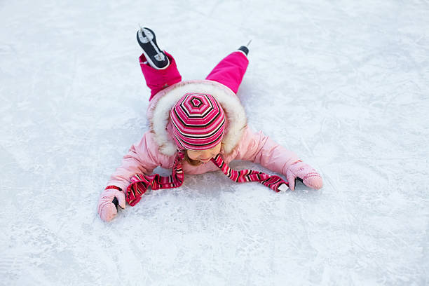 menina caiu para o rinque de patinação no gelo - playground snow winter little girls - fotografias e filmes do acervo