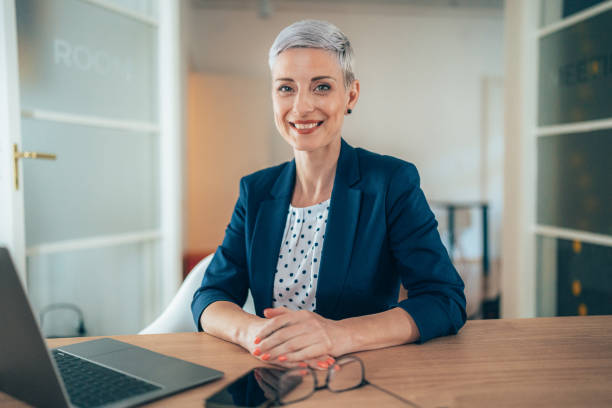 Business woman at the office Portrait of happy smiling business woman sitting i the office bank manager stock pictures, royalty-free photos & images