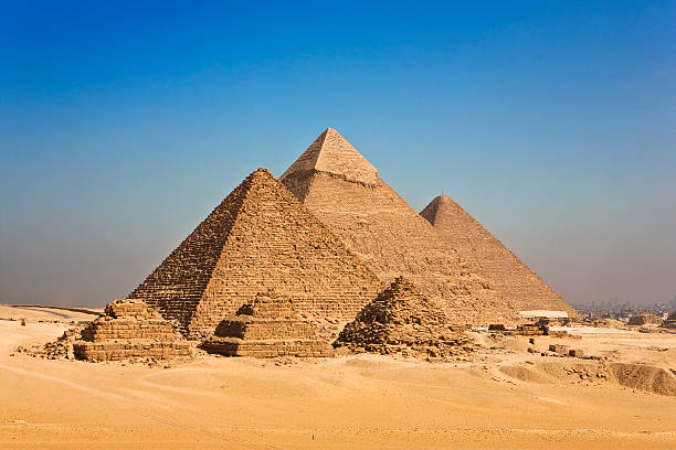 Pyramids of Giza against blue sky in Cairo, Egypt Egypt. Cairo - Giza. General view of pyramids from the Giza Plateau (on front side: three pyramids popularly known as Queens' Pyramids; next in order from left: the Pyramid of Menkaure /Mykerinos/, Khafre /Chephren/ and Chufu /Cheops/ - known as the Great Pyramid). The Pyramid Fields from Giza to Dahshur is on UNESCO World Heritage List khafre photos stock pictures, royalty-free photos & images