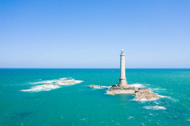 The Lighthouse of Cap de la Hague and the waves of the Channel in Europe, France, Normandy, the English Channel, in spring, on a sunny day. stock photo