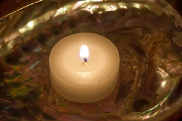Abalone seashell with a lit candle. Stock Image.