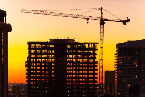 istock Silhouette of Crane and Building Under Construction at Dusk. 1362129164
