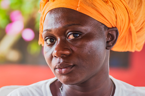 African woman with orange headdress looking into the camera. Photo taken in Ghana Ada Foah