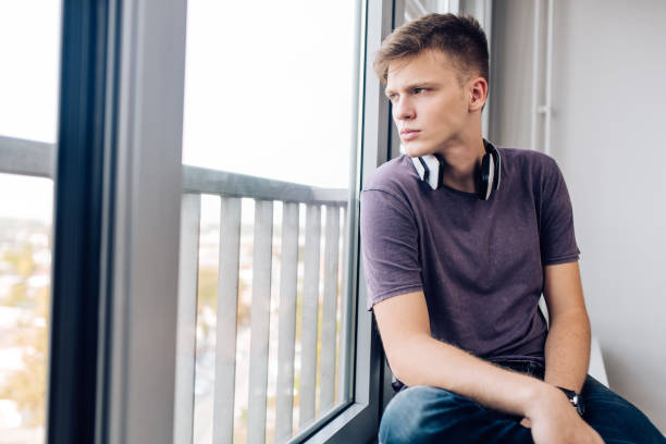 istock Portrait of a thoughtful boy looking through the window 1362135818