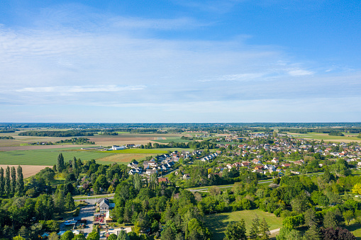 This landscape photo was taken in Europe, in France, in the Centre region, in the Loiret, in summer. We see the houses near the city of Sully sur Loire, under the Sun.