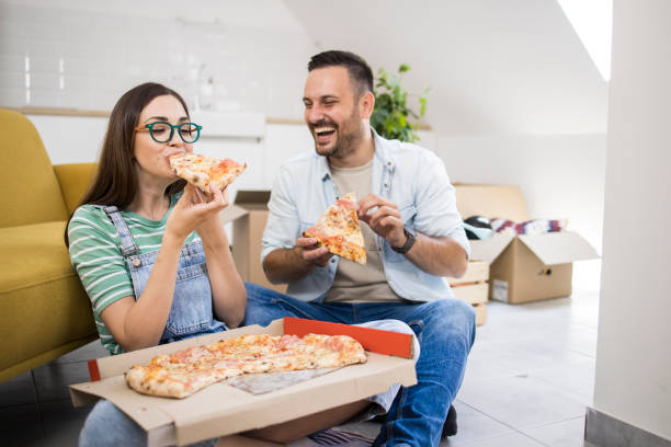 istock Young couple enjoying pizza while moving home 1362139489