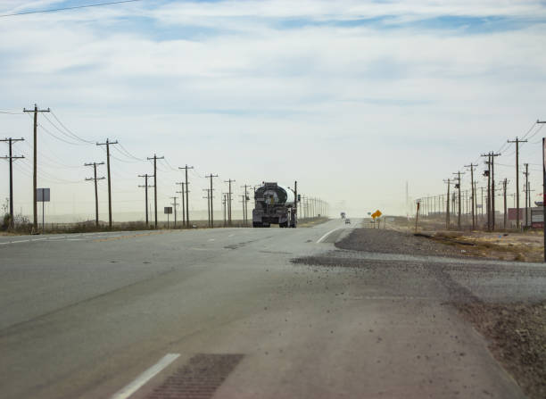 A tanker truck travels along US Highway 285 South near Orla, Texas in Reevess County. A tanker truck travels along US Highway 285 South near Orla, Texas in Reevess County. Reeves County is one of the most polluted counties in the United States. Litter and garbage from nearby oil fields line the sides of the road. carlsbad texas stock pictures, royalty-free photos & images