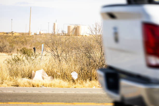 A pick up truck passes by garbage that has been left alongside of Highway 285 through Reeves, County, Texas in the Permian Basin. A pick up truck passes by garbage that has been left alongside of Highway 285 through Reeves, County, Texas in the Permian Basin. carlsbad texas stock pictures, royalty-free photos & images