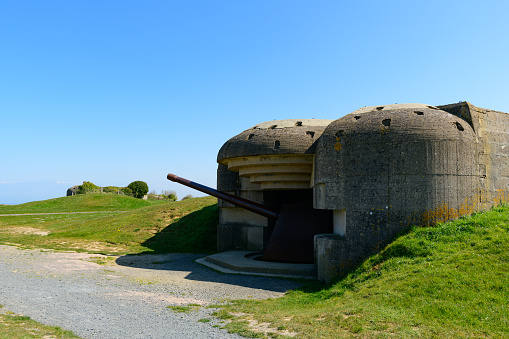 This landscape photo was taken in Europe, in France, in Normandy, towards Arromanches, in Longues sur Mer, in the spring. We see A cannon of the battery of Longues-sur-Mer, under the Sun.