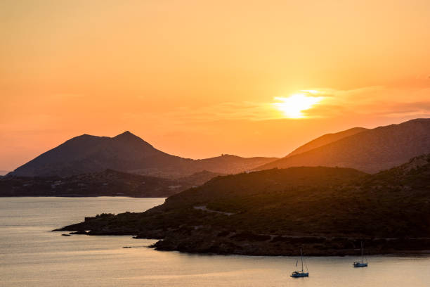 Sunset sea view with orange sky and the silhouette mountains background