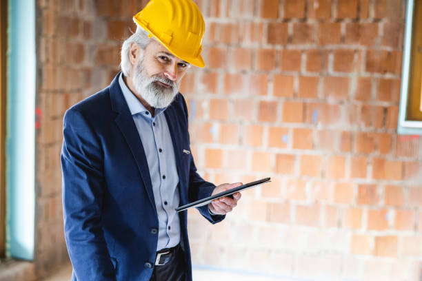 istock Portrait of construction site supervisor in hard hat inspecting new construction project using a tablet 1362142445