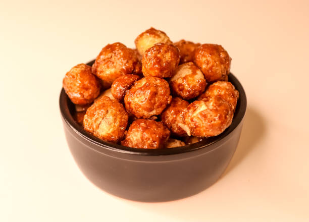 istock Selective focus of many candied macadamia nuts spinning in a small bowl. 1362143269