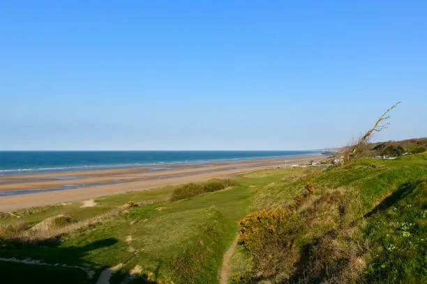 Photo of The beach of the Overlord landing of Omaha beach seen from the steep cliffs in Europe, France, Normandy, towards Arromanches, in Colleville, in spring, on a sunny day.