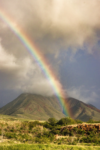 Wide angle shot of rainbow over west maui monuntains.