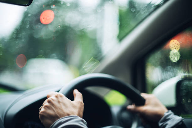 istock Hands of a woman driving a car 1362166341