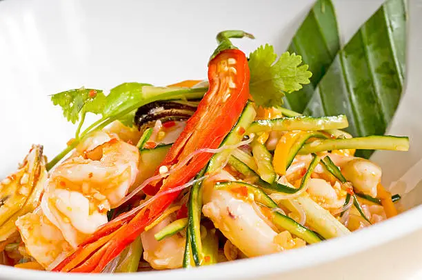 fresh seafood thai style salad with glass noodles on a bowl close up