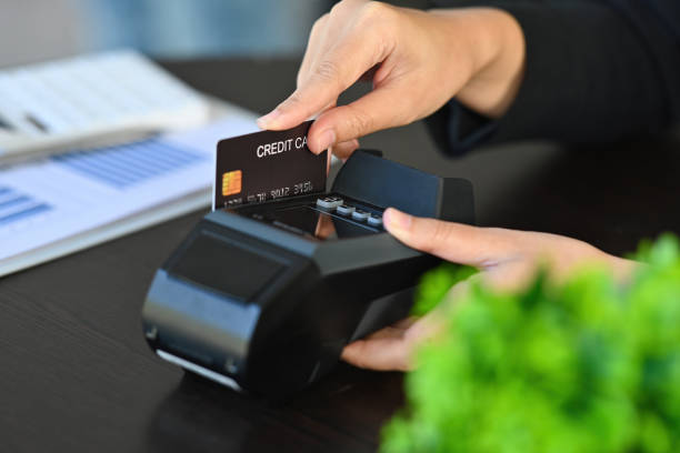istock Cropped image of customer's hand doing payment by using a credit card at the credit card reader. 1362176446